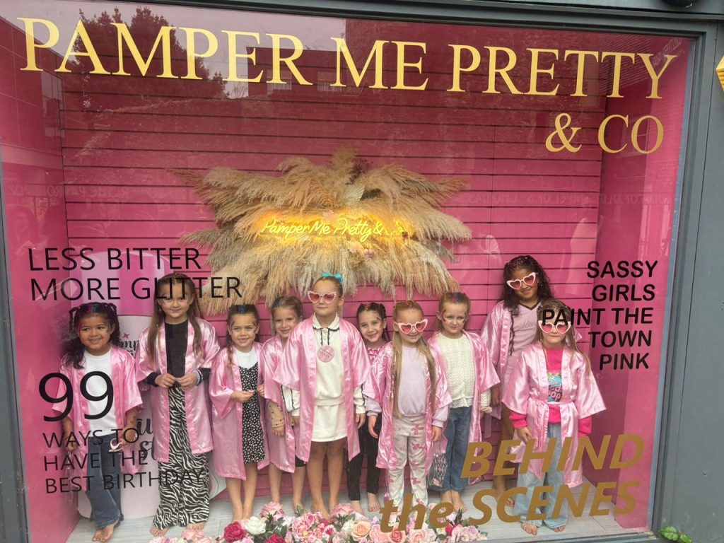 Children in pink robes outside the Pamper Me Pretty shopfront