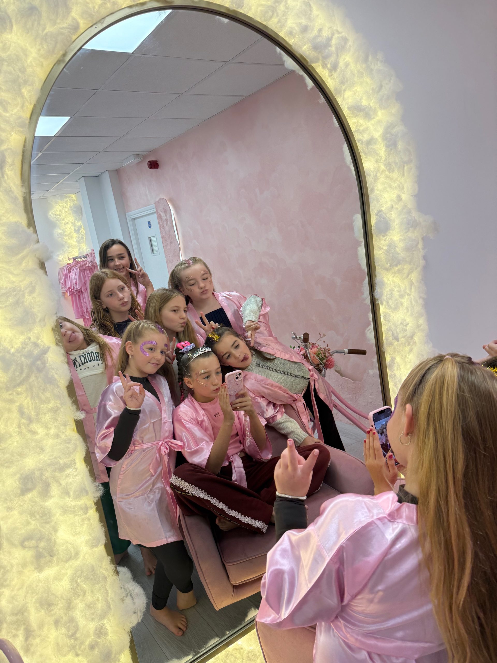 Children getting ready at the makeup mirror during a pamper party package